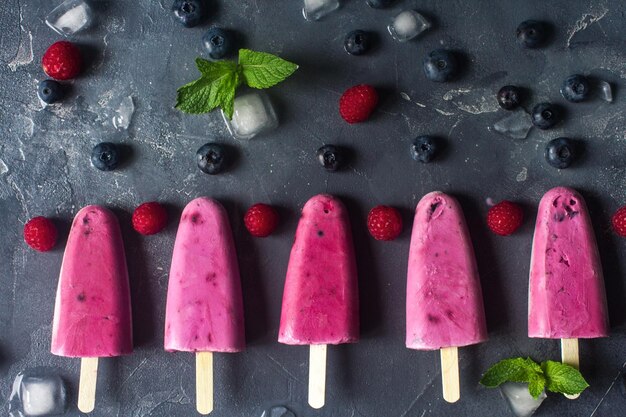 Homemade frozen fruit popsicles with fresh natural raspberry and blueberry