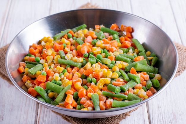 Homemade frozen vegetables in a metal bowl. Healthy food storage concept.