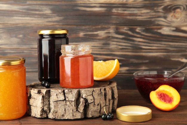 Homemade fruit jam in the jar on brown background. Top view