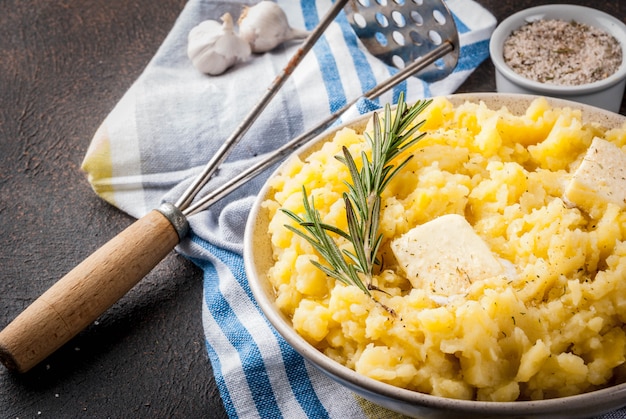 Homemade Garlic Herb Mashed Potatoes, boiled puree, on dark rusty table, copy space