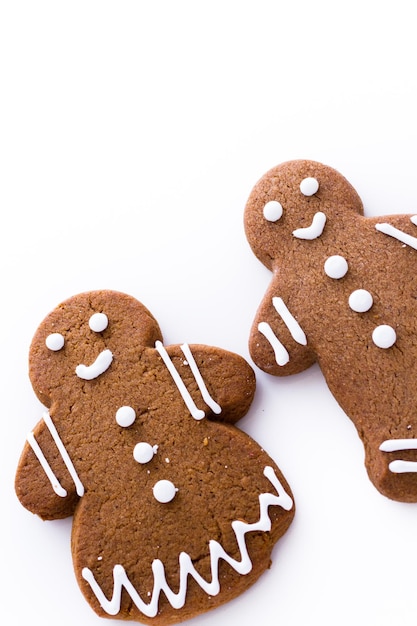 Homemade gingerbread cookies decorated with white icing on white background.