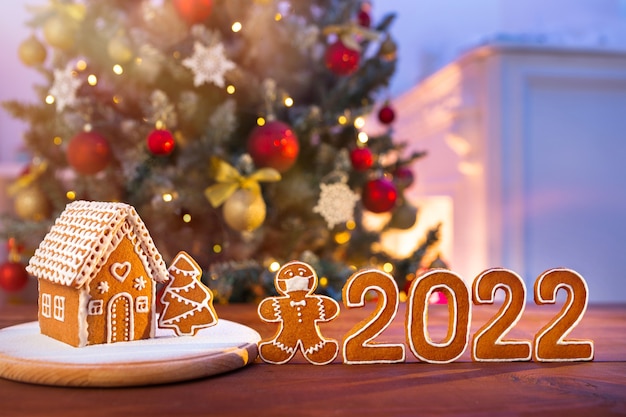 Homemade gingerbread house on the background of a decorated Christmas tree and unfocused lights