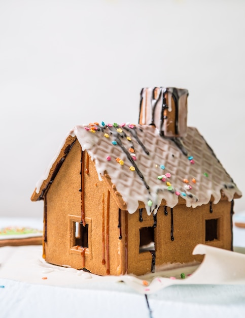 Homemade gingerbread house with glaze and confectionery sprinkling.