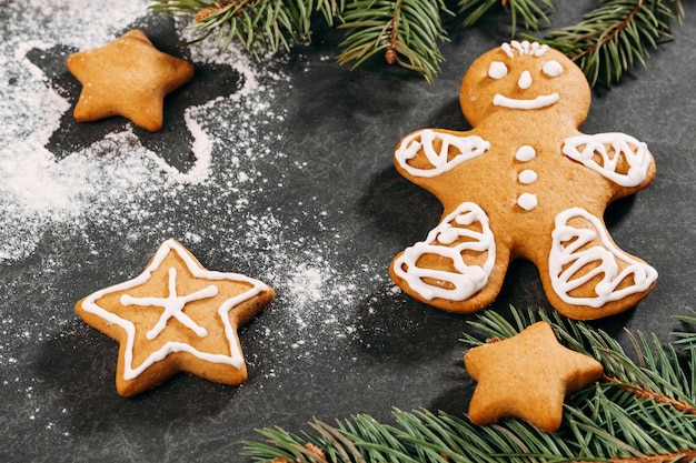 homemade gingerbread man cookies covered with icing on black