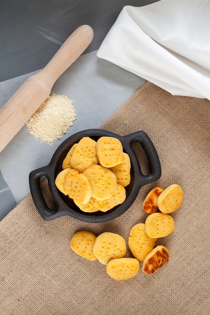 Foto biscotti senza glutine fatti in casa vista dall'alto farina e mattarello su carta da cucina