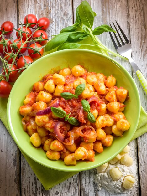 Foto gnocchi fatti in casa con salsa di pomodoro basilico e cipolle