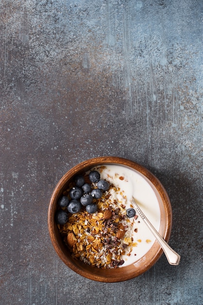 Homemade granola muesli with blueberries on dark grey, vertical top view