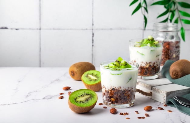 Homemade granola parfait with kiwi fruit in glasses Healthy breakfast Space for text