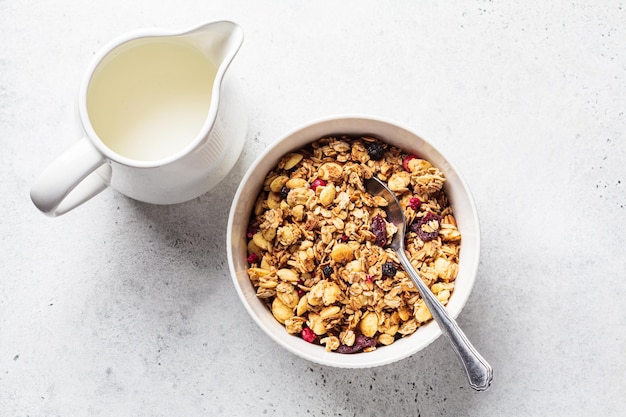 Homemade granola in white bowl gray background top view Muesli bowl for healthy breakfast