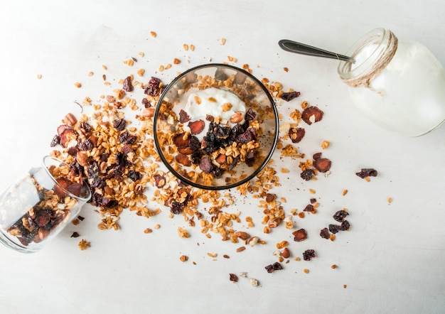 Homemade granola with dried fruits and nuts, organic yogurt in jar.