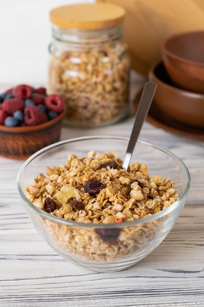 Homemade granola with raisins, nuts and berries in a glass bowl