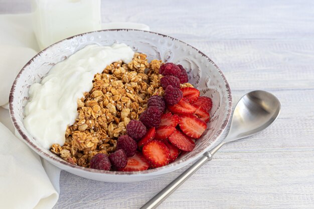 Homemade granola with strawberry slices and yogurt