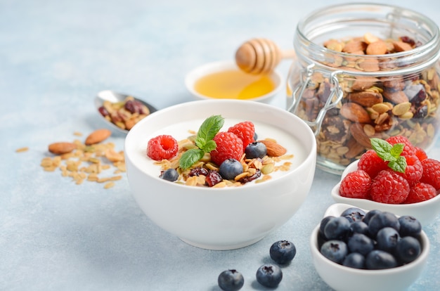 Homemade granola with yogurt and fresh berries, healthy breakfast concept.