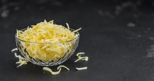 Фото Домашний тертый сыр крупным планом на сланцевой плите