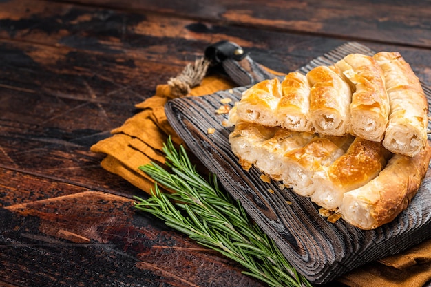 Homemade greek spanakopita pie with organic cheese on wooden board Wooden background Top view Copy space