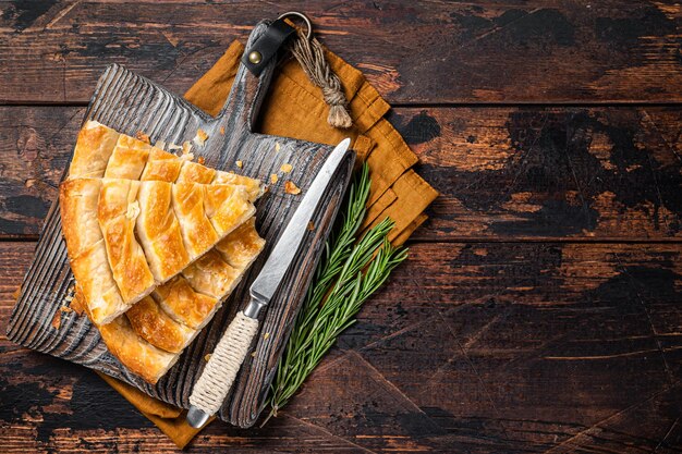 Homemade greek spanakopita pie with organic cheese on wooden board Wooden background Top view Copy space