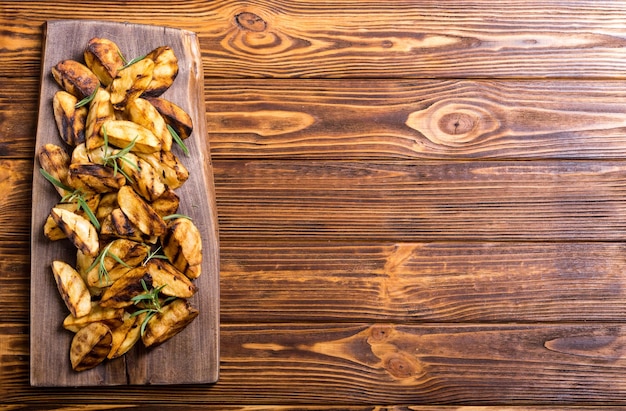 Homemade grilled potatoes with rosemary Food on rustic background