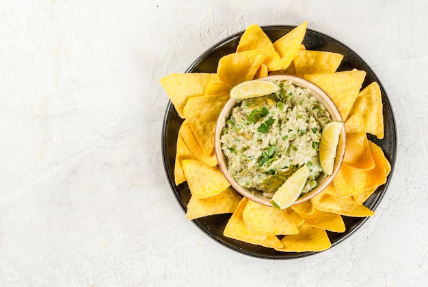 Homemade guacamole in bowl, served with nachos