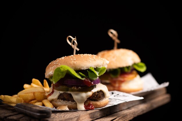 Homemade hamburger or burger with french fries on wooden table Close up