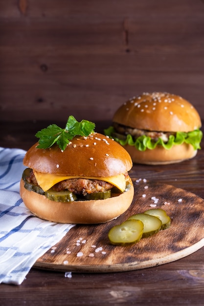 Homemade hamburger with beef and cucumbers on wood