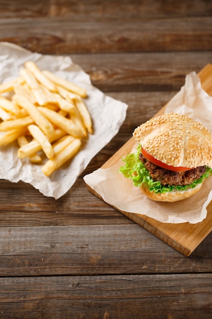 Hamburger fatti in casa e patatine fritte sul tavolo di legno