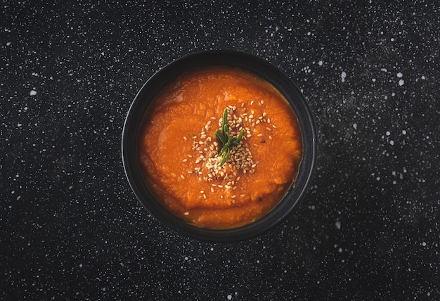 Homemade and healthy pumpkin cream with bread from above on  dark table. Flat lay