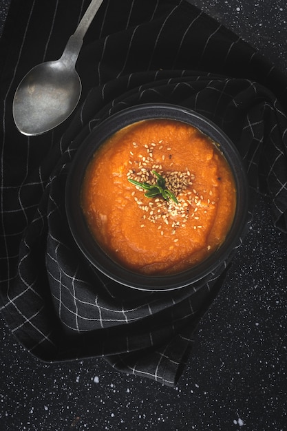 Homemade and healthy pumpkin cream with bread from above on  dark table. Flat lay