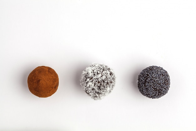 Homemade Healthy vegan Raw Energy Balls with carob, poppy and coconut isolated on white background, top view