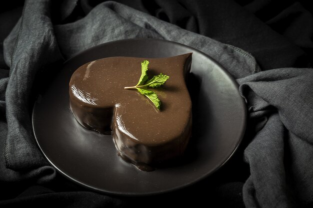 Homemade heart shaped chocolate cake on black background