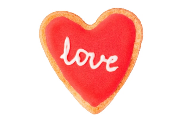 Photo homemade heart shaped cookie with red icing and lettering love isolated on white background