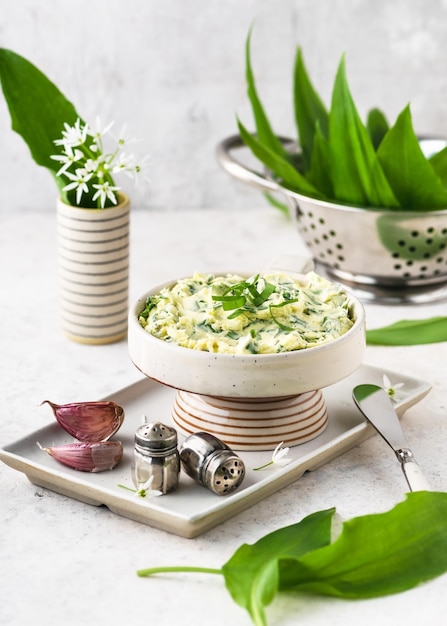 Homemade herb butter with wild garlic leaves lemon juice pepper and salt in a ceramic bowl