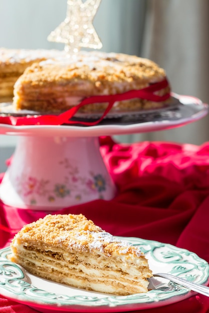 Фото Крошка домашнего медового торта с золотой рождественской звездой и кусочек торта на тарелке рождественская концепция