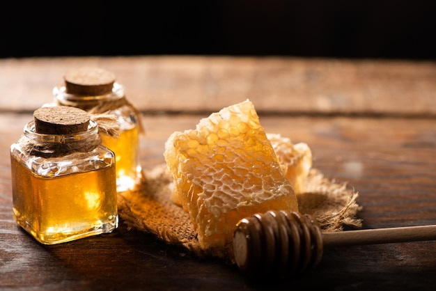 Homemade honey jar with honeycomb on a rustic wooden table close up