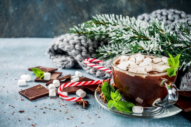 Cioccolata calda fatta in casa con menta, bastoncino di zucchero e marshmallow