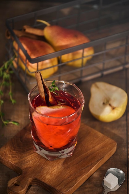 Homemade hot mulled pear cider with a cinnamon stick on a wooden background