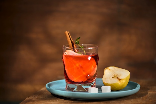 Homemade hot mulled pear cider with a cinnamon stick on a wooden surface