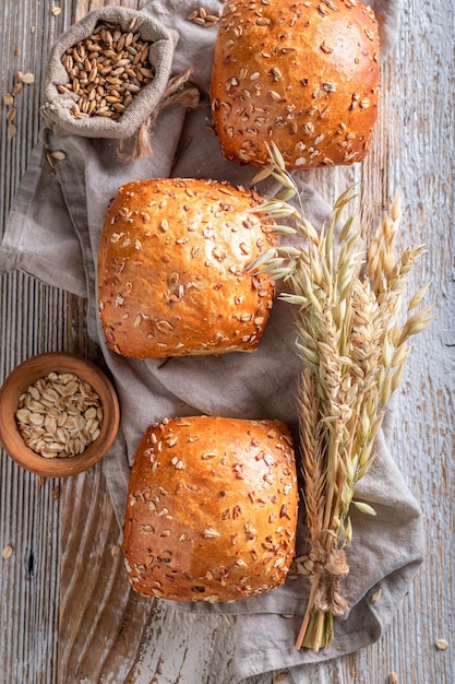 Homemade and hot oat buns with ears of grains