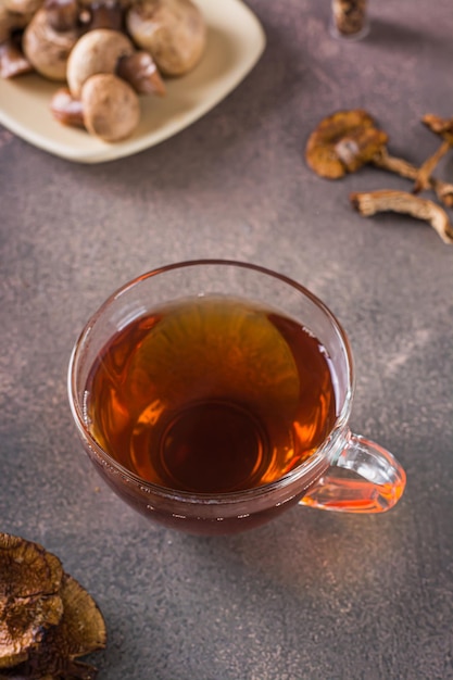 Домашний горячий чай из сушеных грибов в чашке на столе вертикальный вид