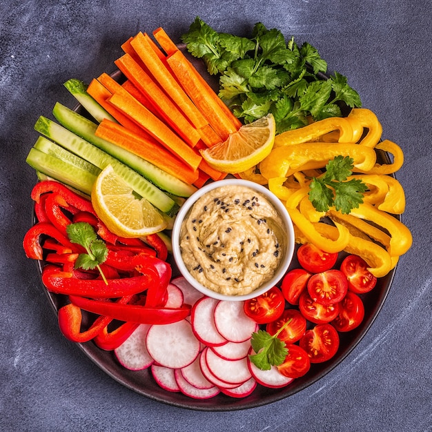 Homemade hummus with fresh vegetables, top view.