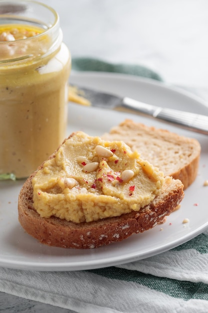 Homemade hummus with pine nuts and bread