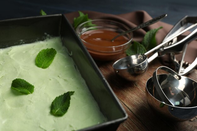 Homemade ice cream in frozen metallic container on dark wooden background