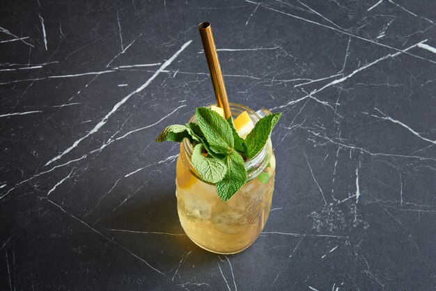 Homemade ice tea in glass jar with metal straw