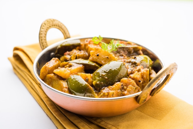 Homemade Indian spicy eggplant and potato curry also known as aloo Baigan ki sabzi in hindi, served in kadhai or white bowl, selective focus