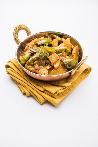 Homemade Indian spicy eggplant and potato curry also known as aloo Baigan ki sabzi in hindi, served in kadhai or white bowl, selective focus