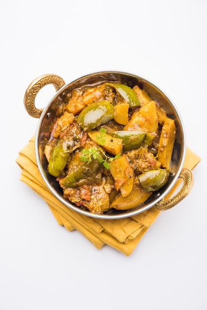 Homemade Indian spicy eggplant and potato curry also known as aloo Baigan ki sabzi in hindi, served in kadhai or white bowl, selective focus