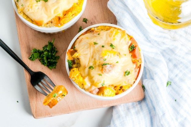 Homemade italian bread casserole strata with cheese, egg and ham, white background copy space top view