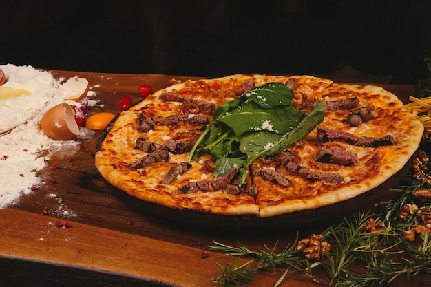 Homemade Italian pizza with mozzarella cheese salami tomato sauce pepper arugula and spices