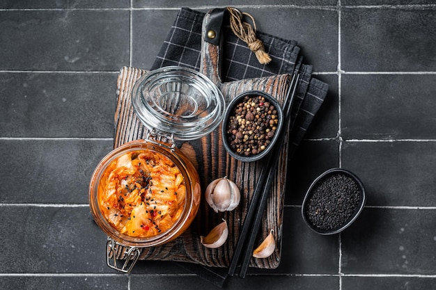 Homemade kimchi in a glass jar traditional Korean cuisine Black background Top view