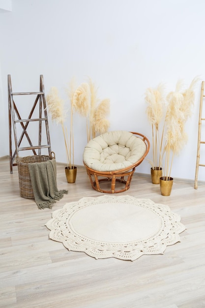 Homemade knitted rug made of thick threads handmade a handmade rug made of beige threads lies in the living room near the armchair the art of knitting