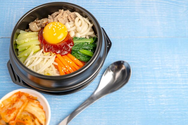 Foto riso misto coreano fatto in casa chiamato bibimbap servito in una pentola di pietra calda